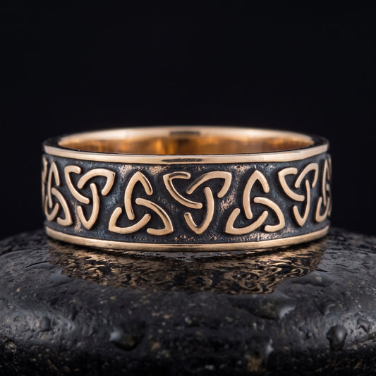 Handmade bronze triquetra ring seen front on, oxidised channel between polished rails
