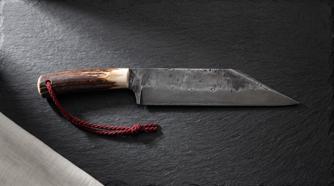Broken-back seax with a straight spine that drops in a sharp angle to the point, antler handle, on dark slate