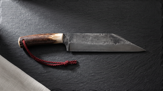 Broken-back seax with a straight spine that drops in a sharp angle to the point, antler handle, on dark slate