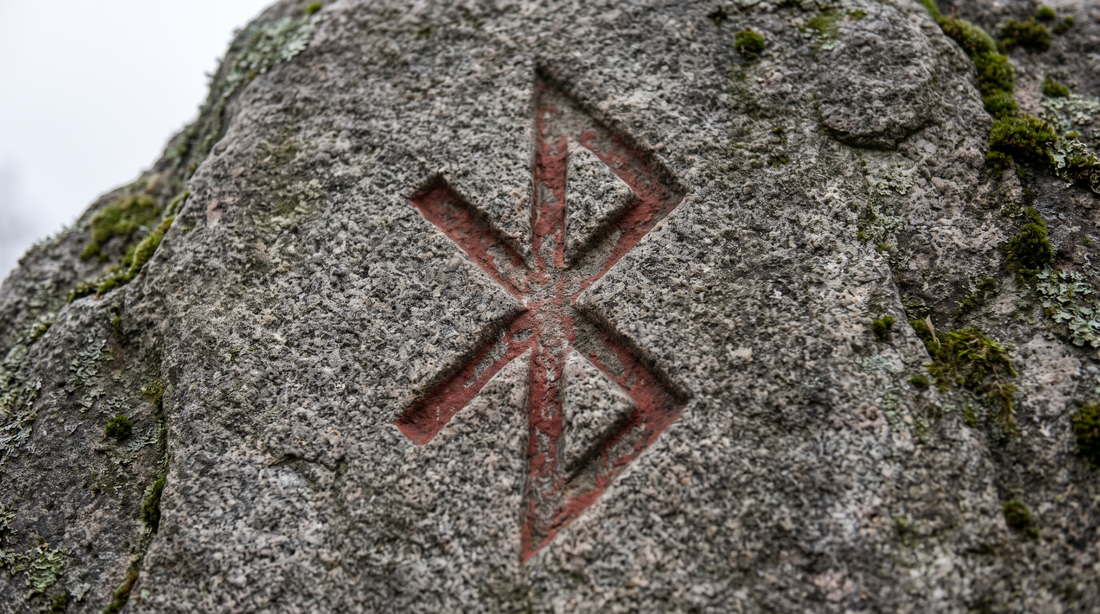Bind rune of Hagall and Bjarkan carved into a runestone, the shape behind the Bluetooth logo