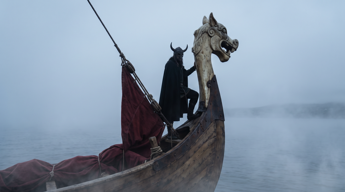Lone Viking chieftain silhouetted on the prow of a longship gliding through thick sea fog