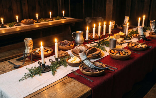 Oak table set for a Norse midwinter feast with drinking horns and candles