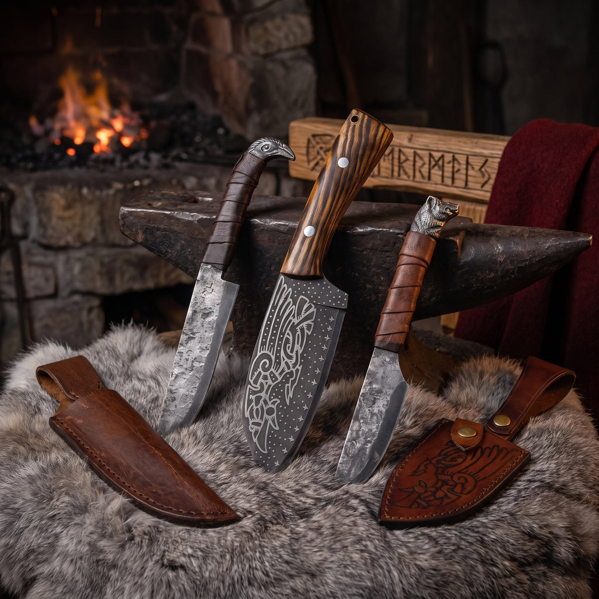 Three hand-forged Viking seax knives — Huginn & Muninn, Odin's Raven and Boar's Head — with their leather sheaths on fur beside the stone forge