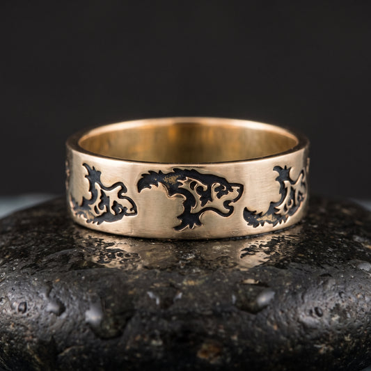 Handmade bronze Viking ring seen front on, a row of stylised wolves engraved into the flat band