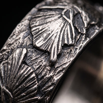 Macro of the carved wolf head and swept mane on the silver Fenrir band