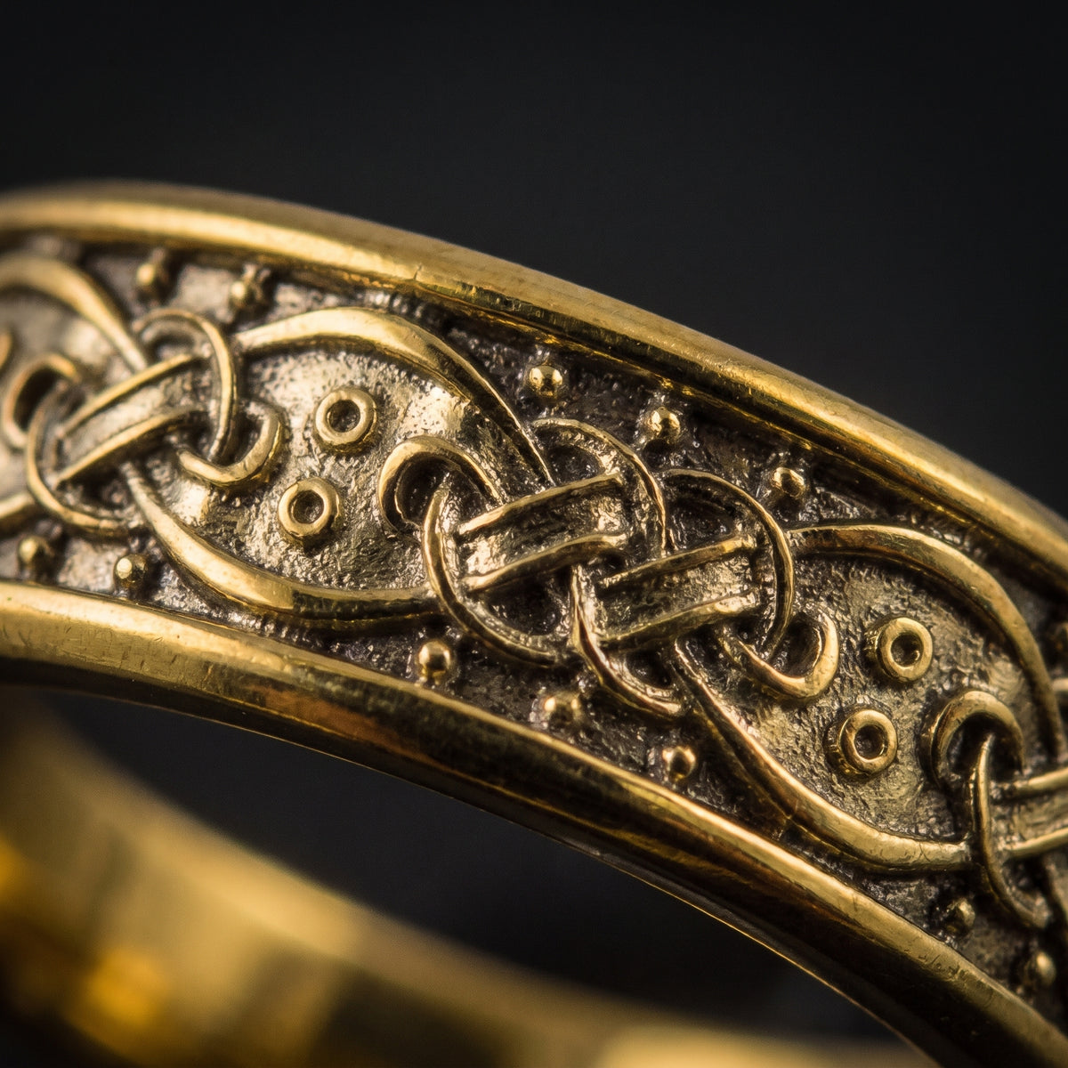 Macro of the gold Norse knotwork and round bosses on the ring