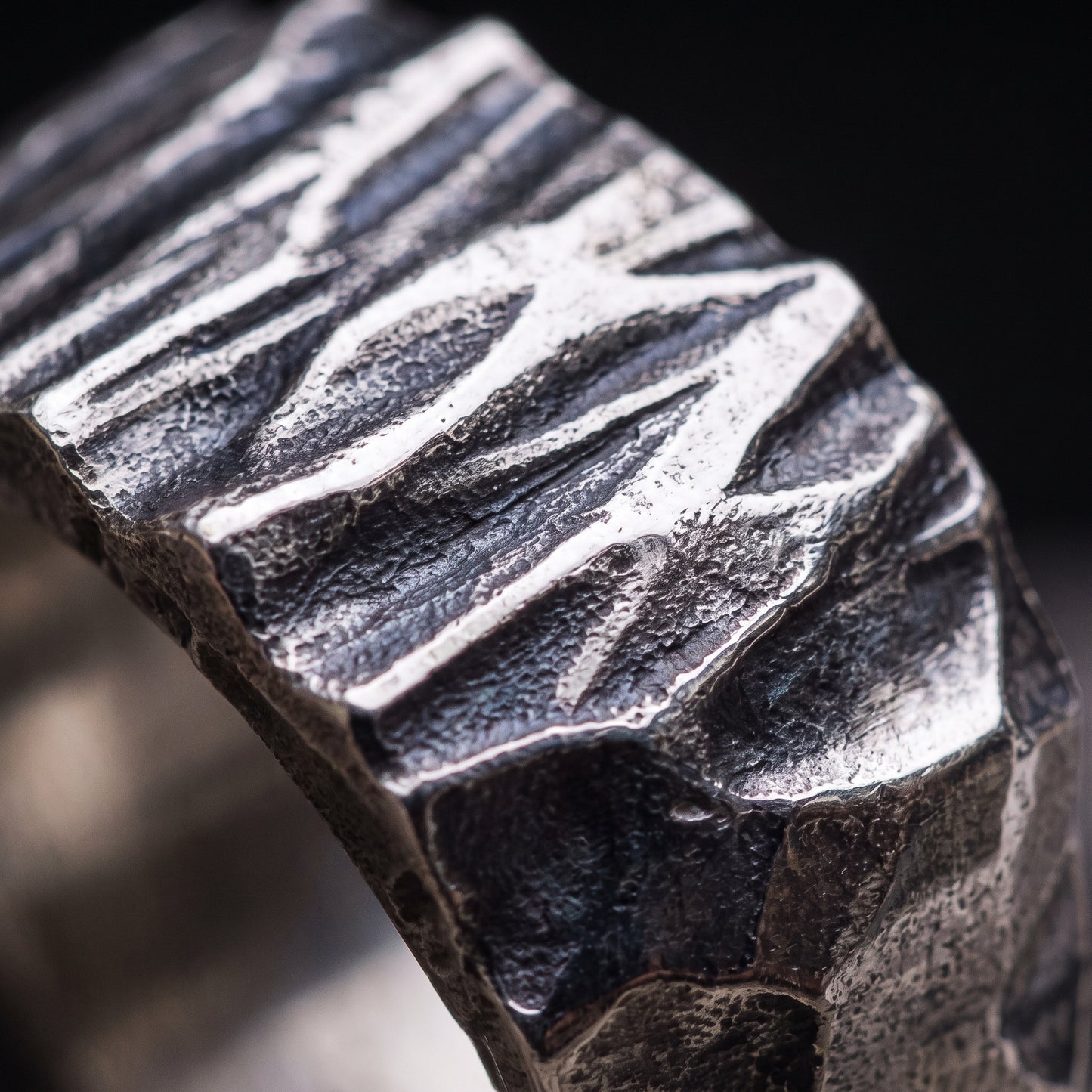 Macro of the hand-hammered, chisel-faceted silver surface