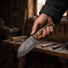 Huginn & Muninn Viking seax knife held in the hand in a workshop, showing its size and the raven-etched blade