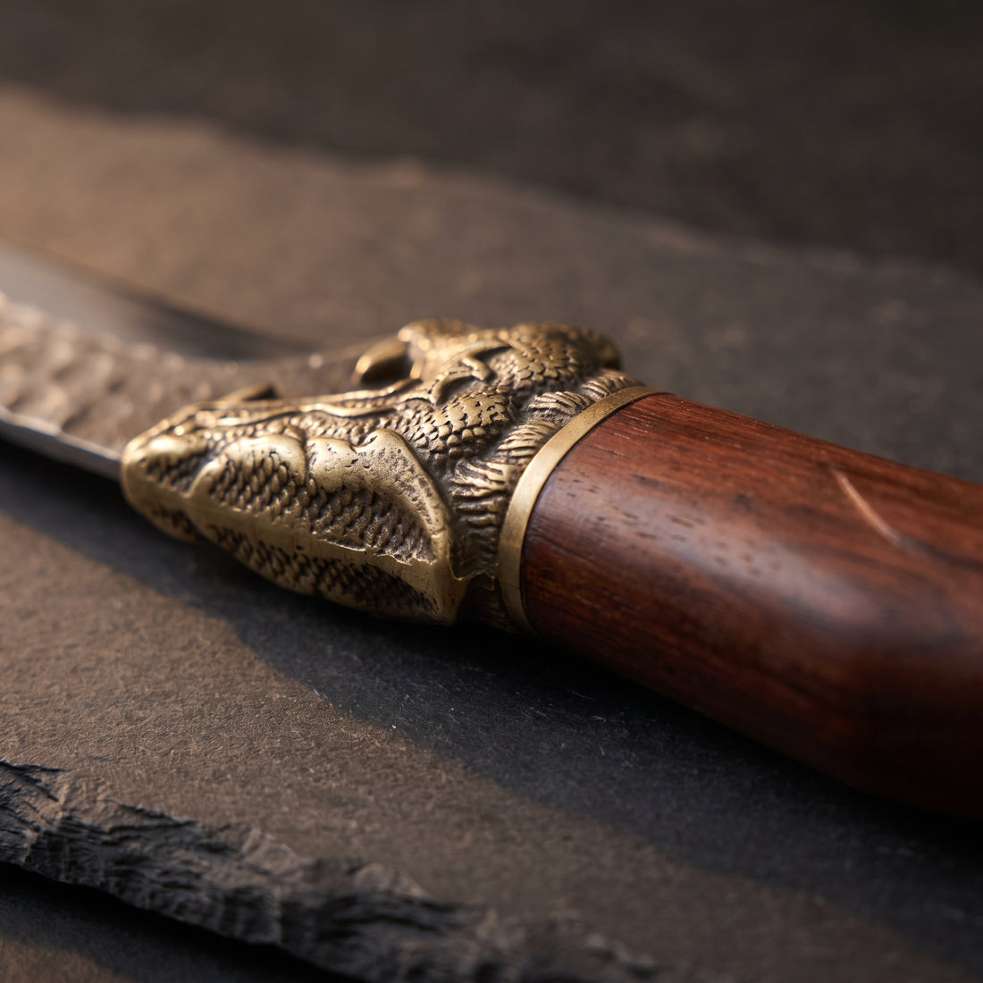 Close-up of the cast brass bolster and rosewood handle where they meet the blade of the Fenrir boning knife