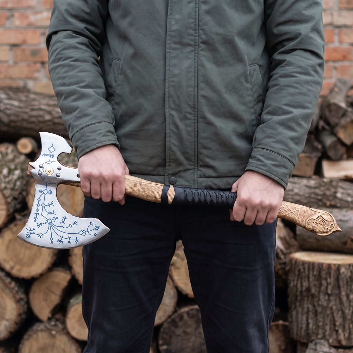 Man holding the Kratos axe in both hands at hip height to show its size