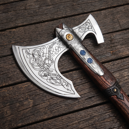 Close-up of the engraved axe head: knotwork on the bearded blade, gold-coloured boss and two blue inlays