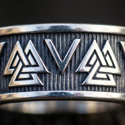 Macro of two Valknut symbols of three interlocking triangles on the silver band