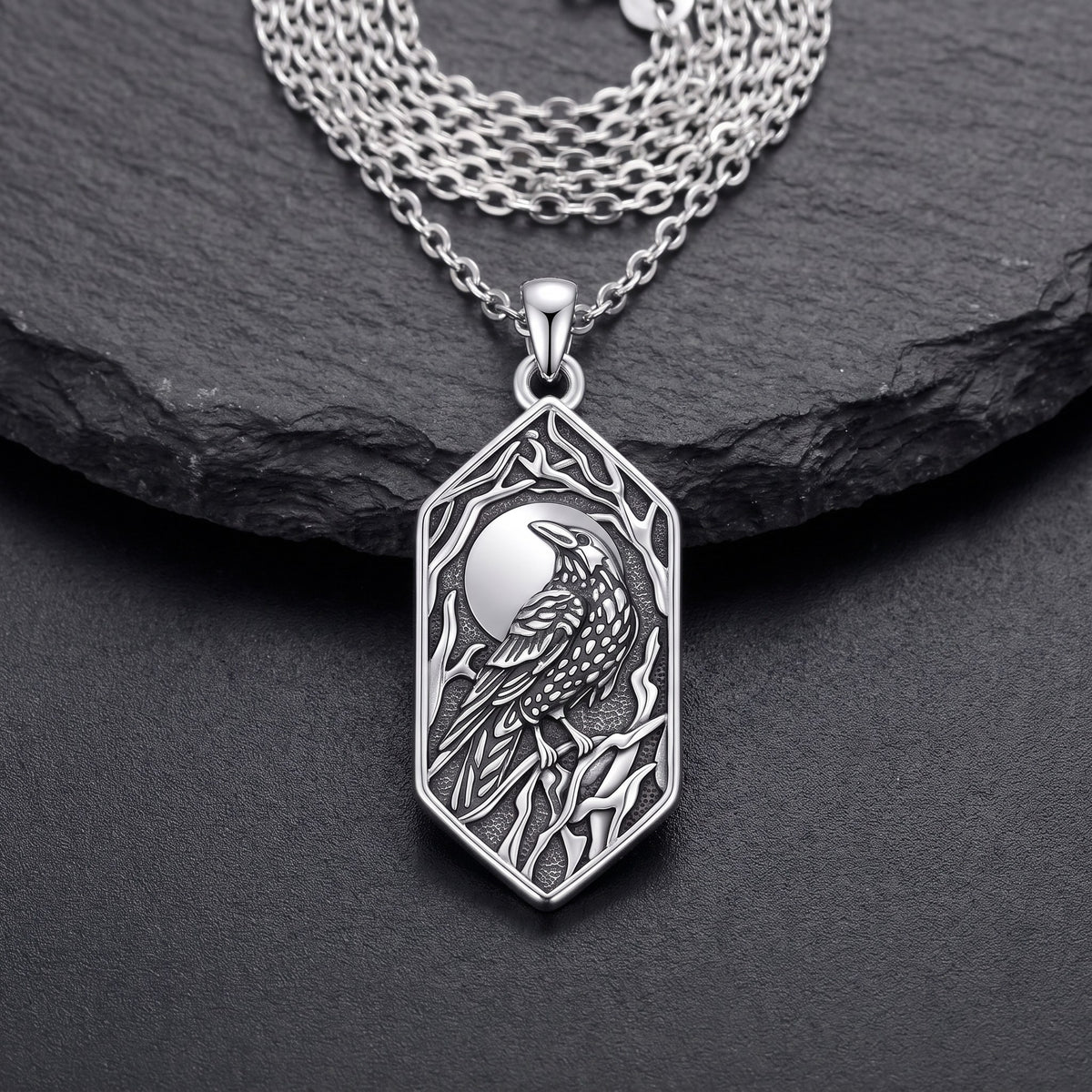 Front view of the sterling silver raven pendant: full moon, raven on a branch and bare branches in oxidized relief