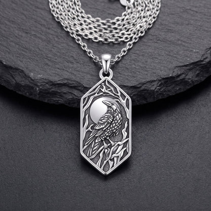 Front view of the sterling silver raven pendant: full moon, raven on a branch and bare branches in oxidized relief