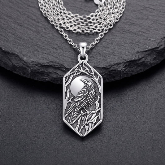Front view of the sterling silver raven pendant: full moon, raven on a branch and bare branches in oxidized relief