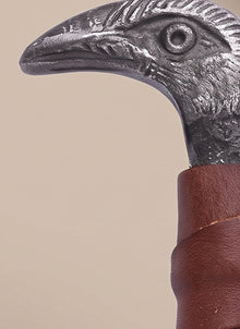 Close-up of the cast raven's-head pommel and leather-wrapped grip on the Raven-Hilt Viking seax knife