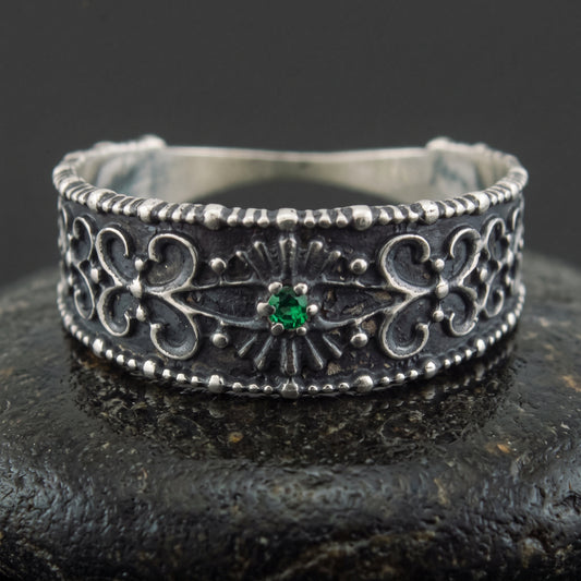 Handmade 925 silver ring seen front on, filigree ornament and a set green gem