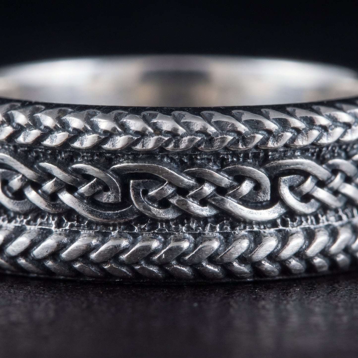 Macro of the braided plait bands and the running interlaced knot on the silver ring