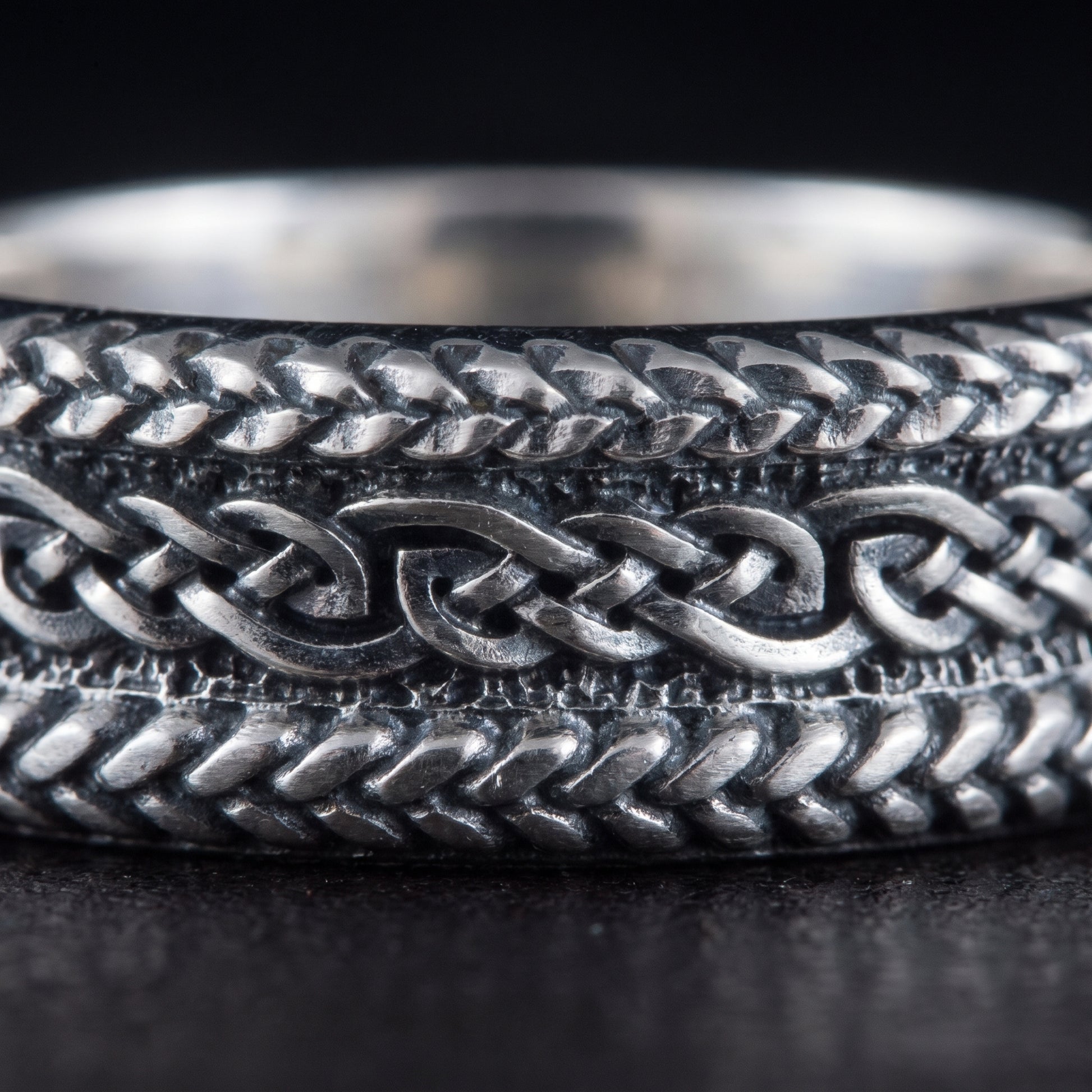 Macro of the braided plait bands and the running interlaced knot on the silver ring
