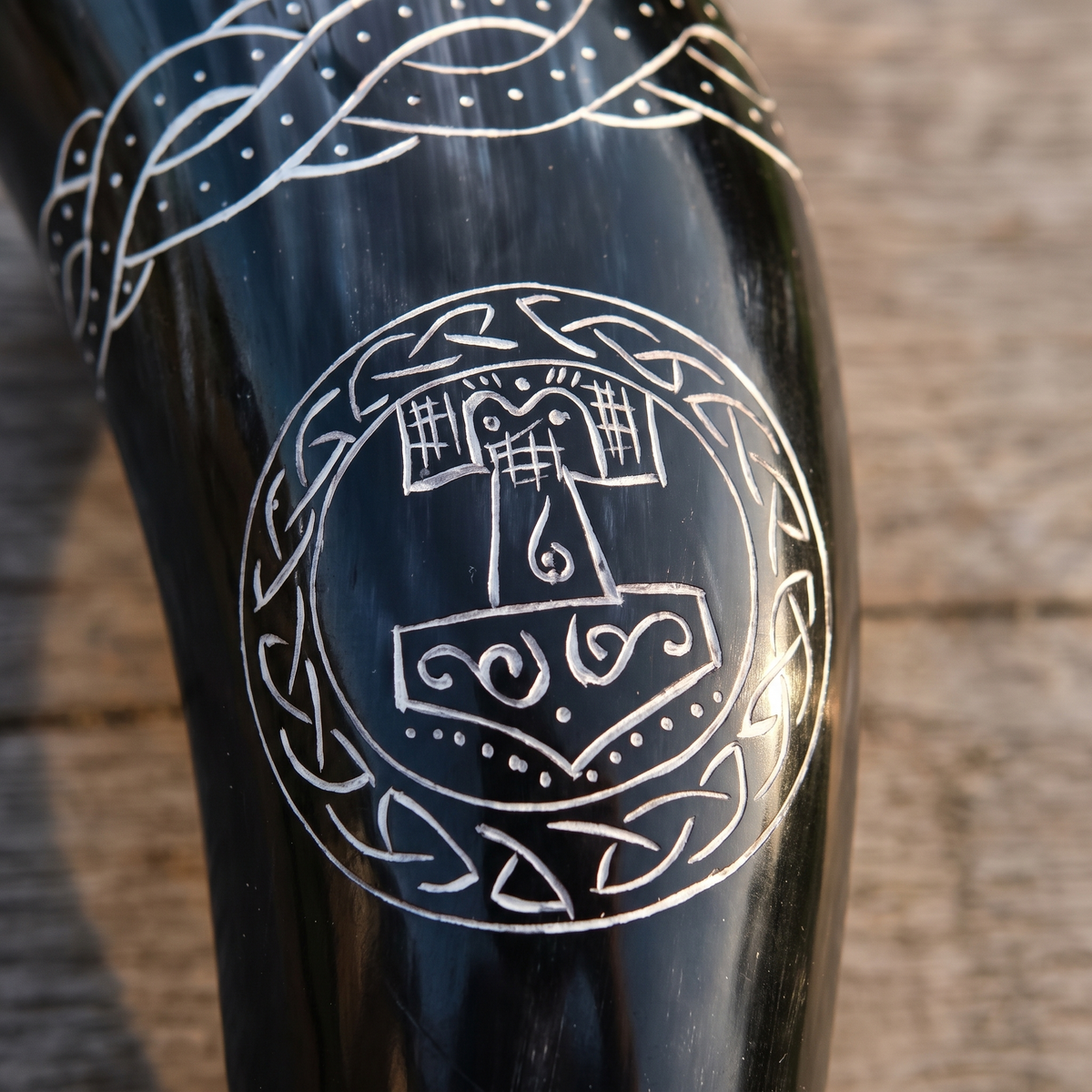 Close-up of the hand-engraved Thor's hammer in a knotwork ring on the drinking horn