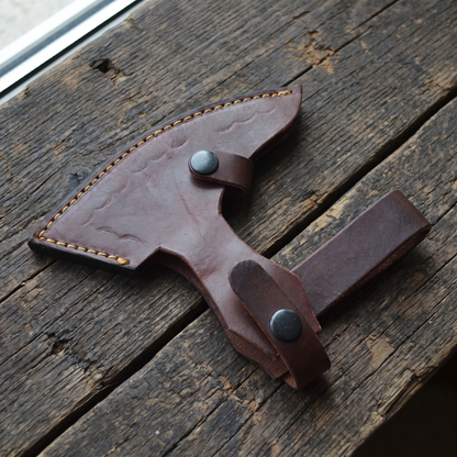 Hand-stitched brown leather axe head sheath with two snap straps and a belt loop