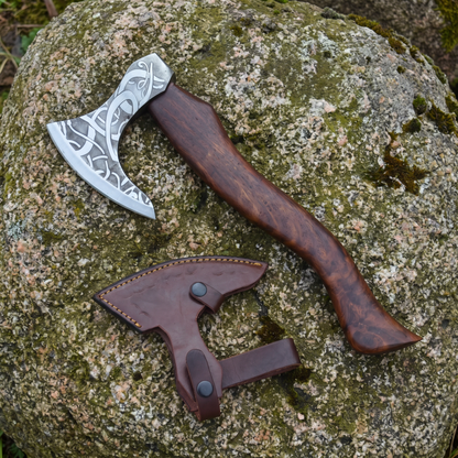Valhalla bearded axe with acid-etched knotwork head and ash wood handle, shown with its leather sheath