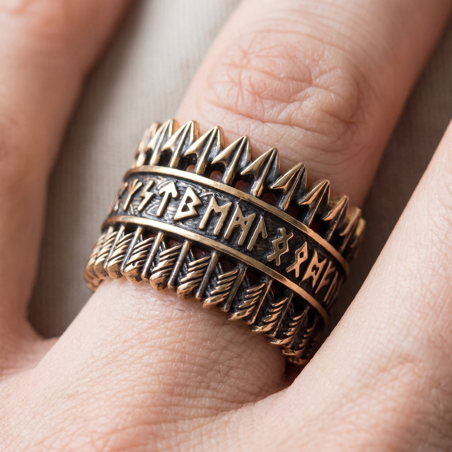 Bronze Viking arrow ring with Elder Futhark runes worn on a finger