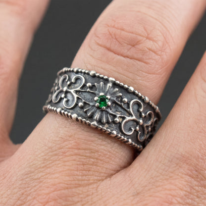 Silver Viking ring with a green stone worn on a finger