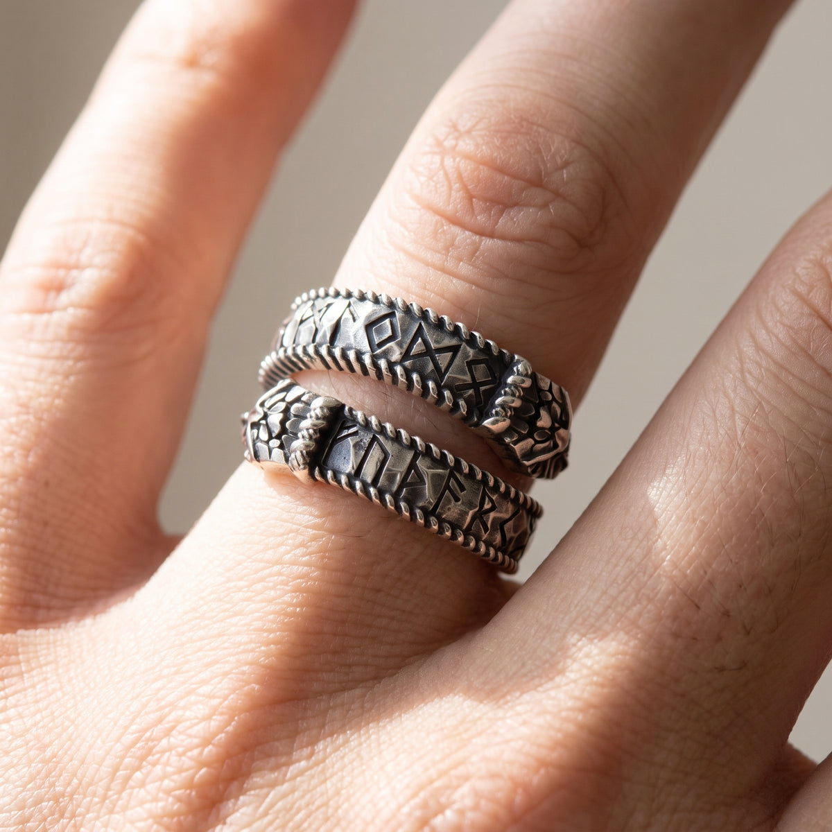 Silver Ouroboros rune ring worn on a finger