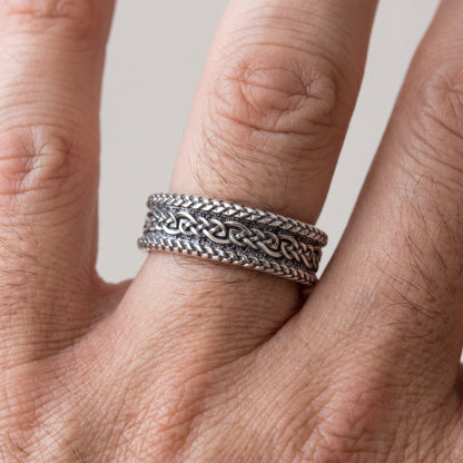 Braided silver Viking wedding ring worn on a finger