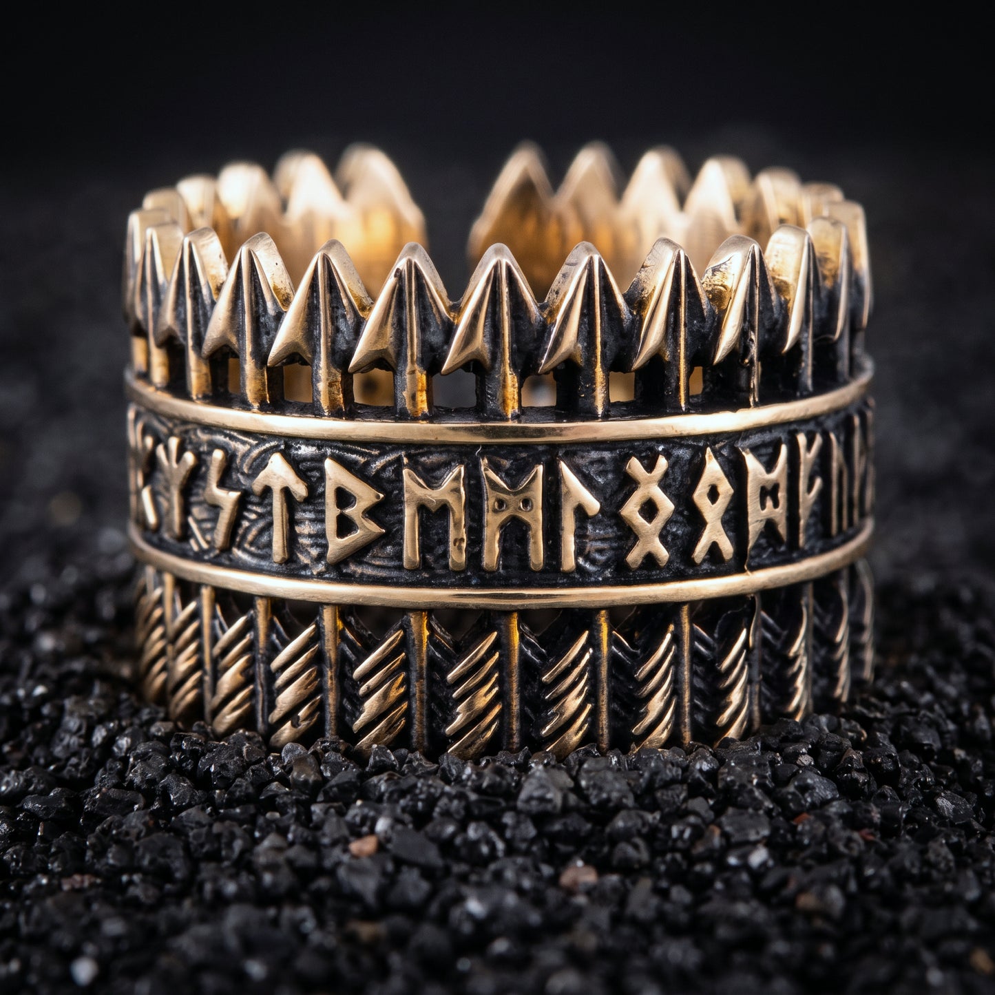 Bronze Viking ring with rows of arrows and Elder Futhark runes on black volcanic sand