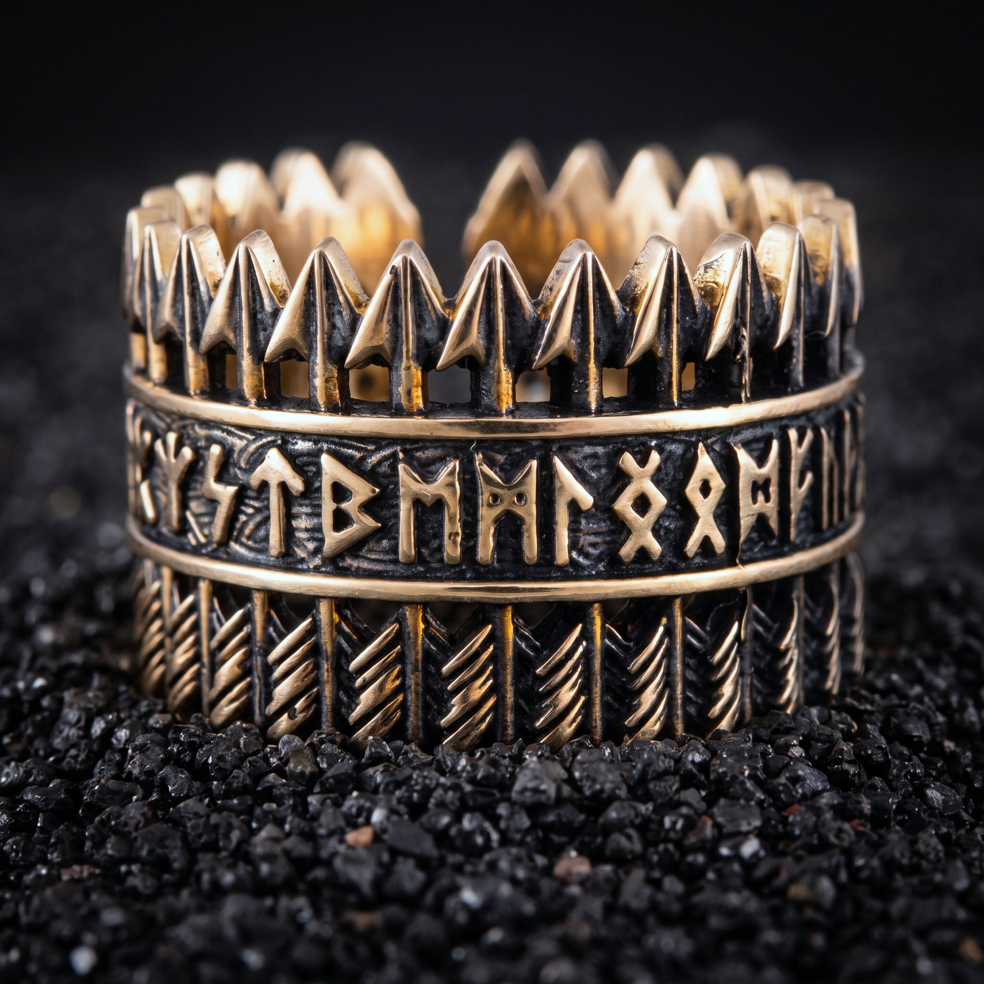 Bronze Viking ring with rows of arrows and Elder Futhark runes on black volcanic sand