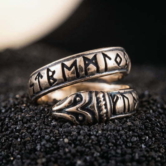 Bronze Ouroboros Viking ring with Elder Futhark runes on black volcanic sand