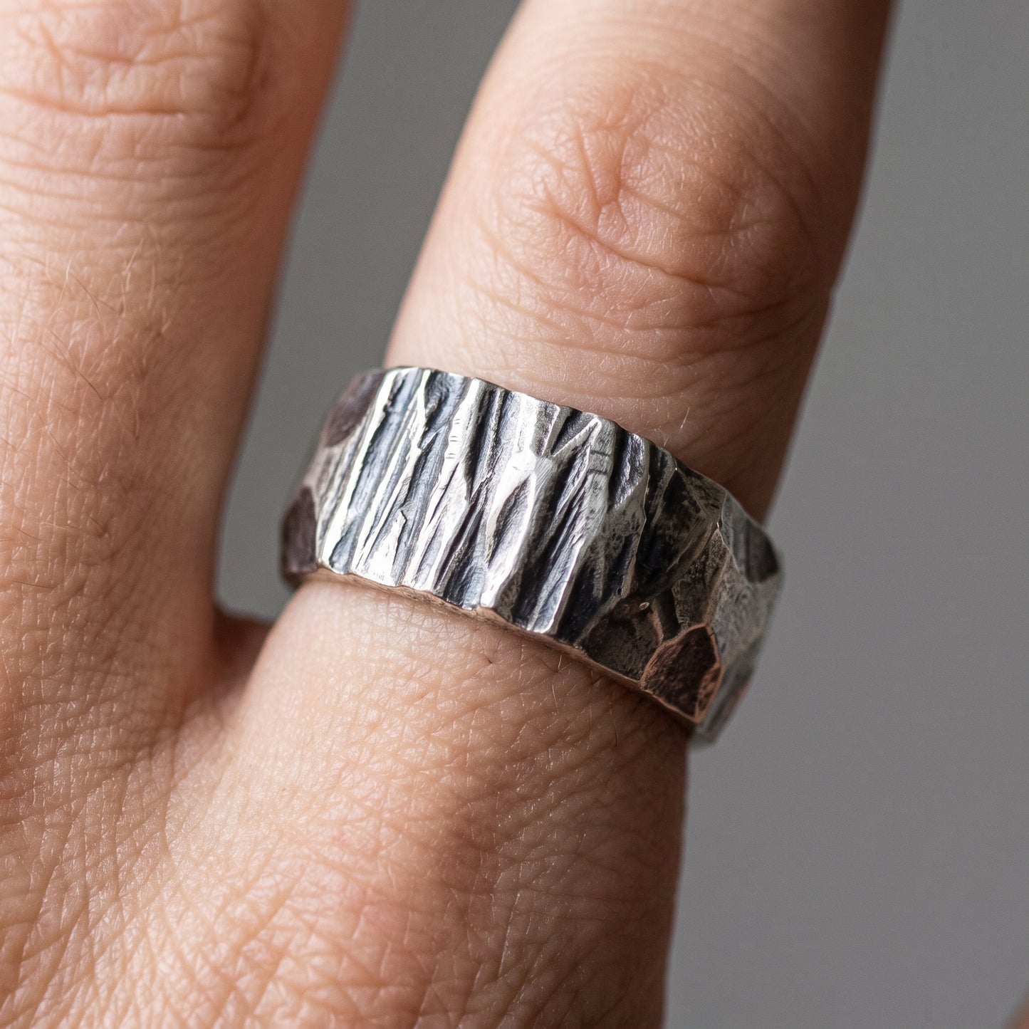 Hammered silver Viking wedding band worn on a finger