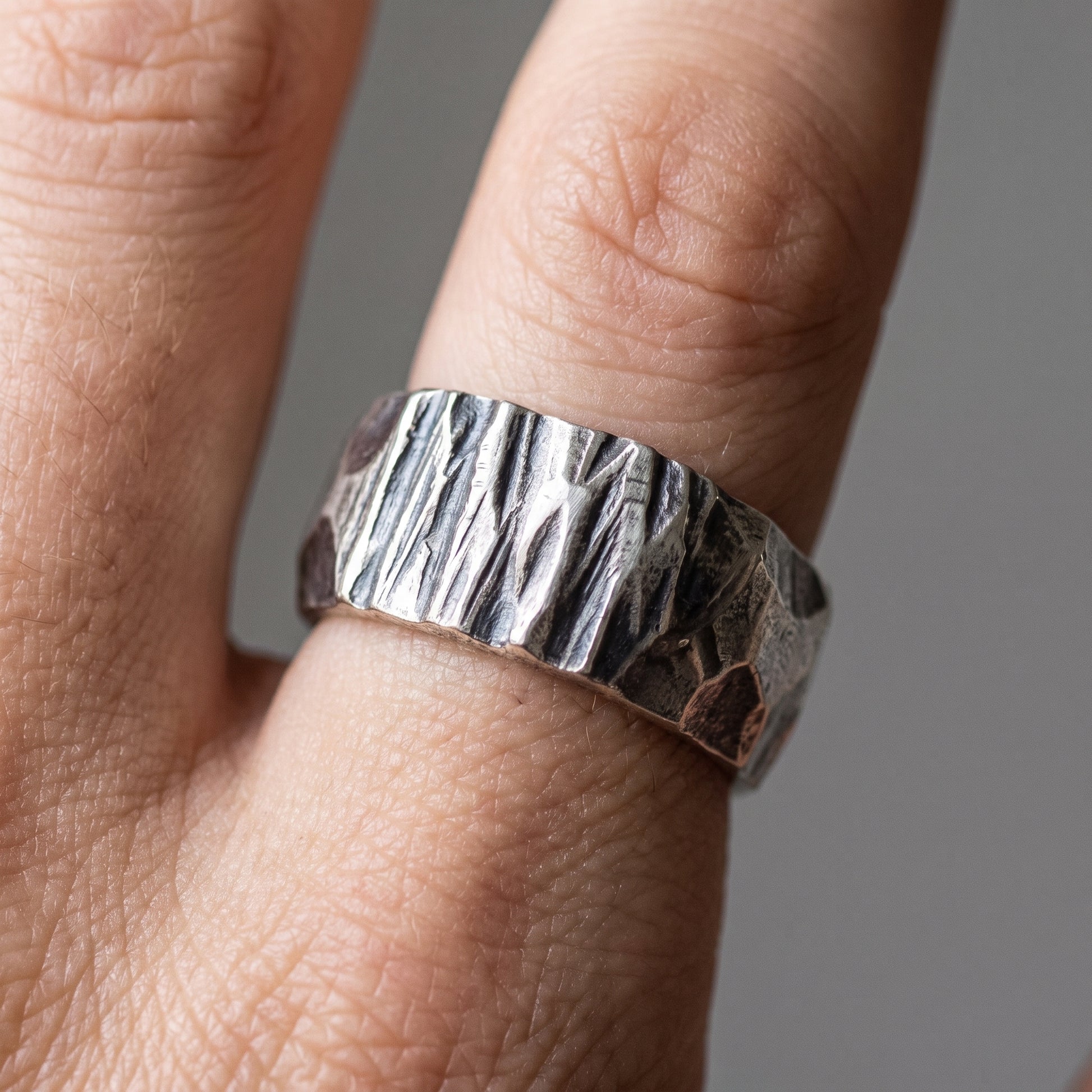 Hammered silver Viking wedding band worn on a finger