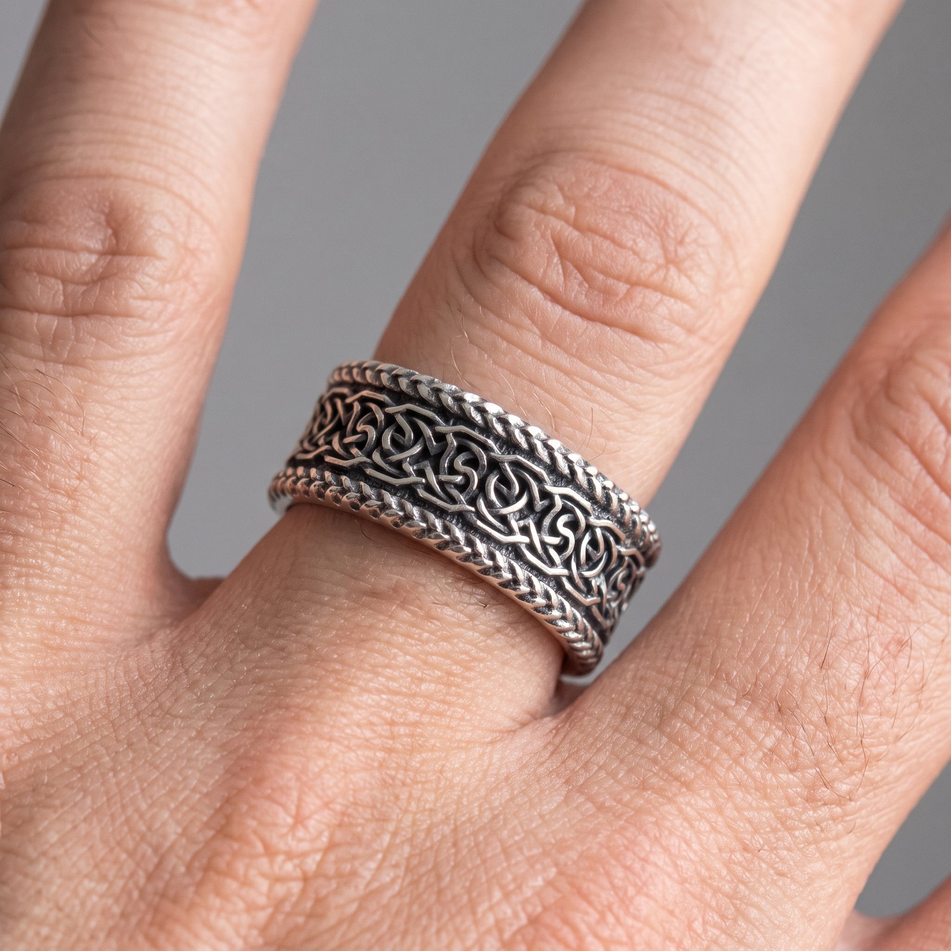 Silver Viking wedding ring with Norse knotwork worn on a finger