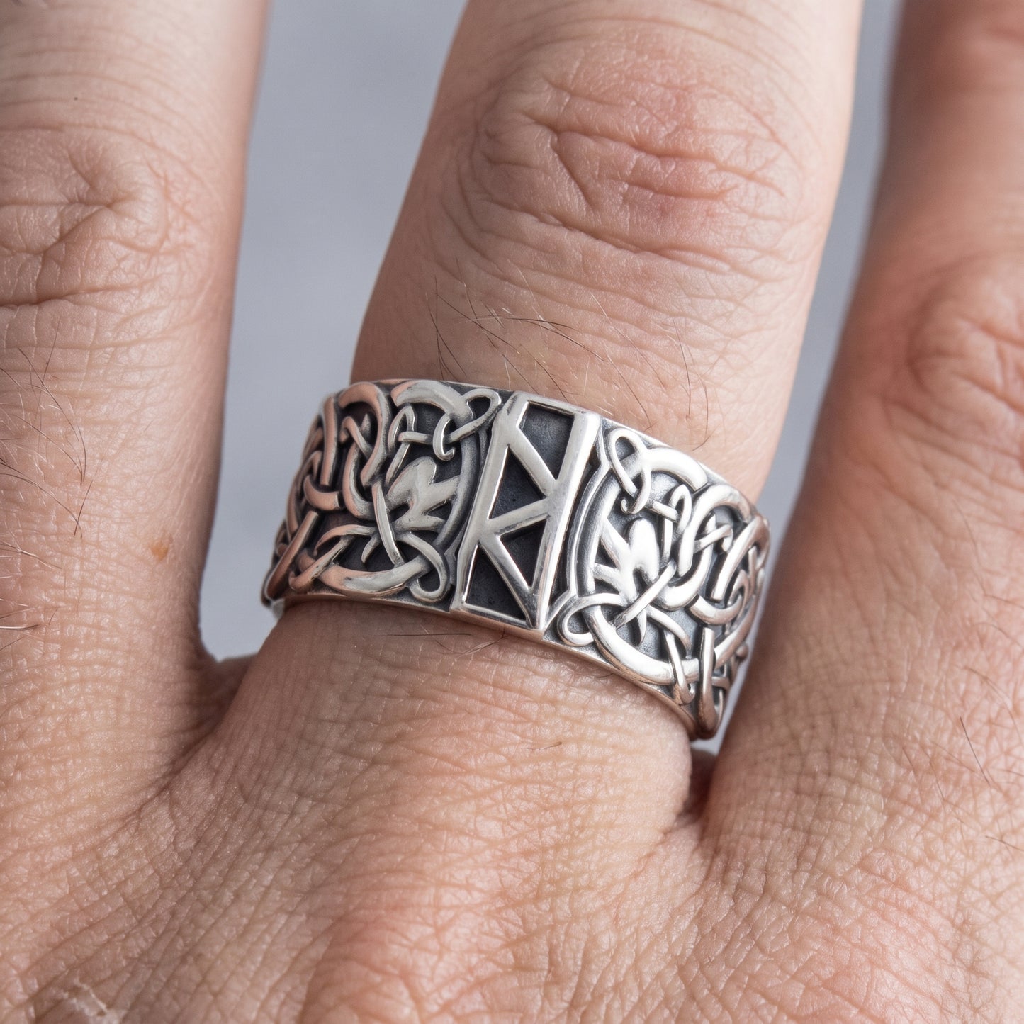 Silver Raido rune Viking ring worn on a finger