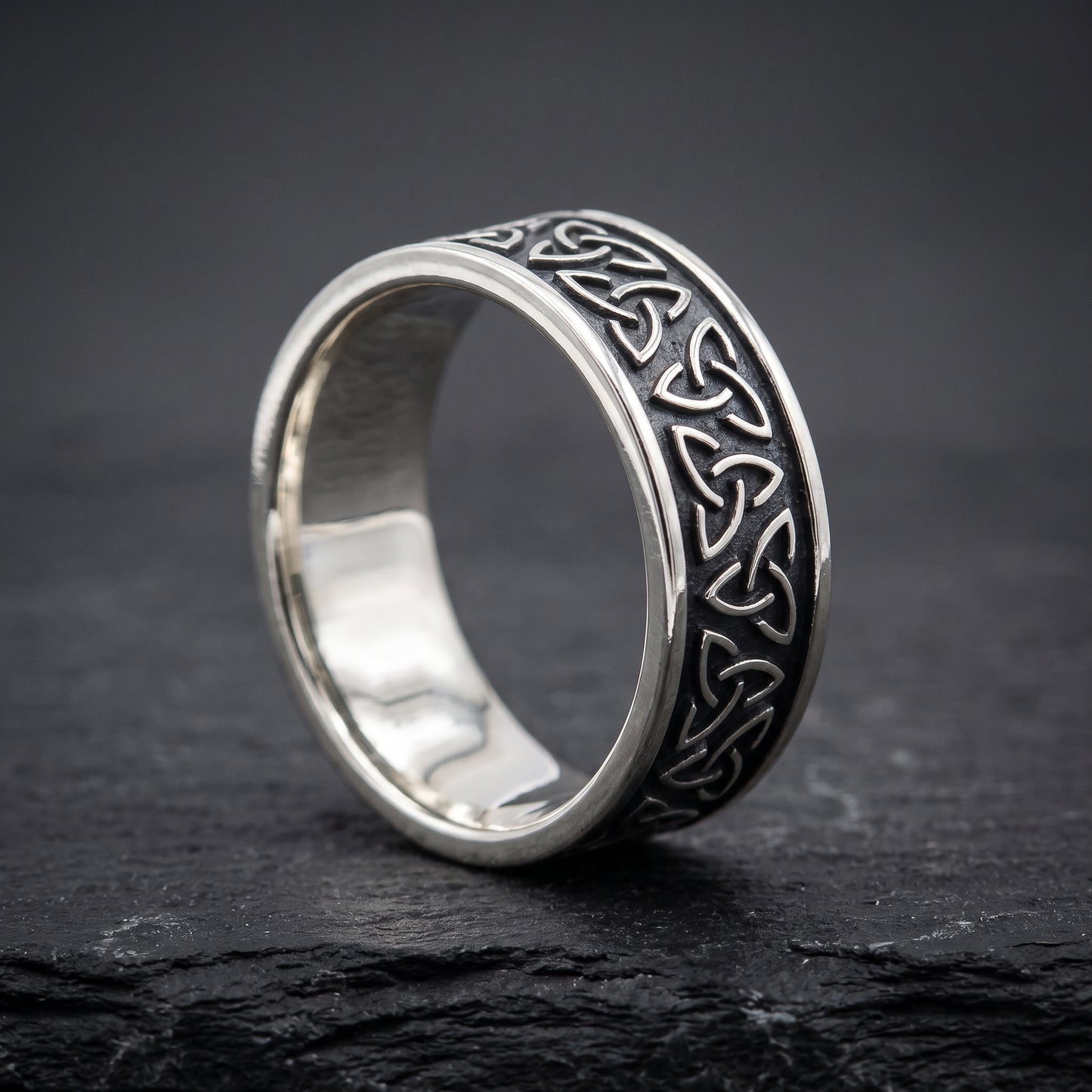 Narrow silver triquetra ring from the side, polished interior visible