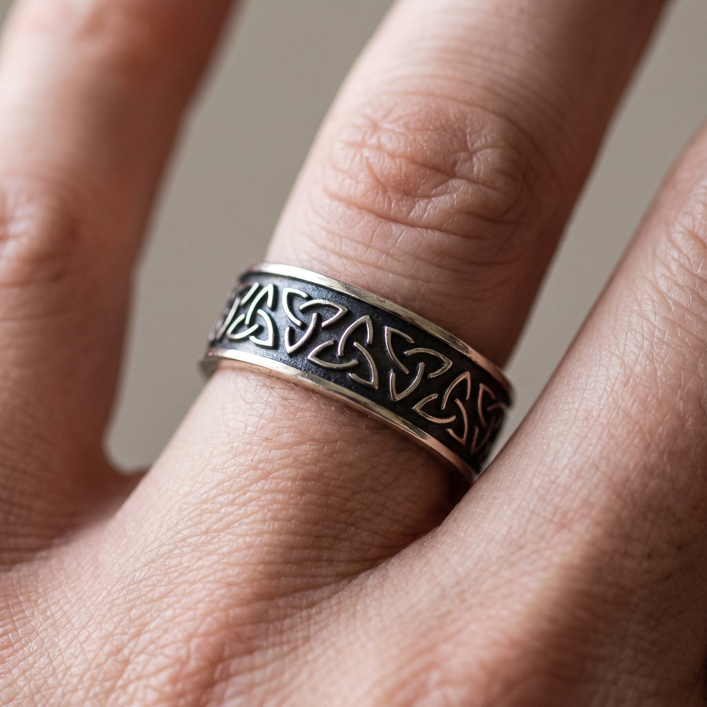 Narrow silver triquetra Viking ring worn on a finger