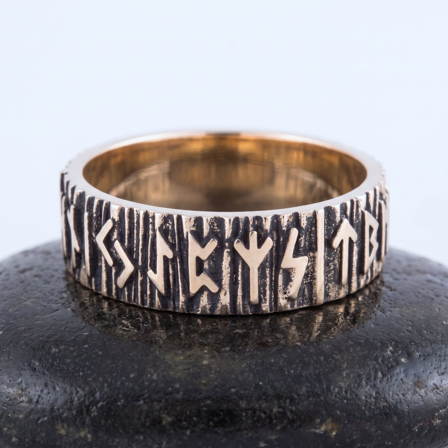 Bronze rune wedding ring seen front on, raised Elder Futhark runes rim to rim
