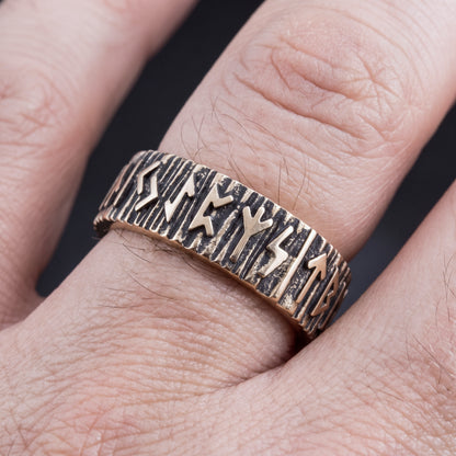 Bronze Elder Futhark rune wedding ring worn on a finger, showing the width of the band