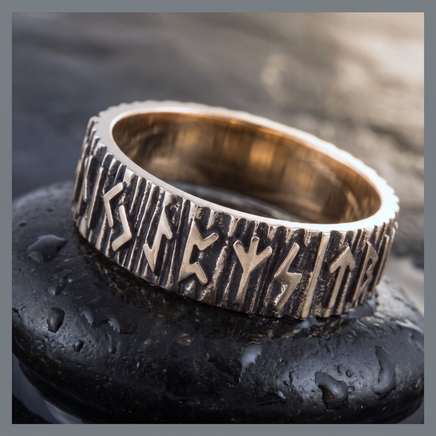 Close view of the raised Elder Futhark runes on the chiselled bronze band