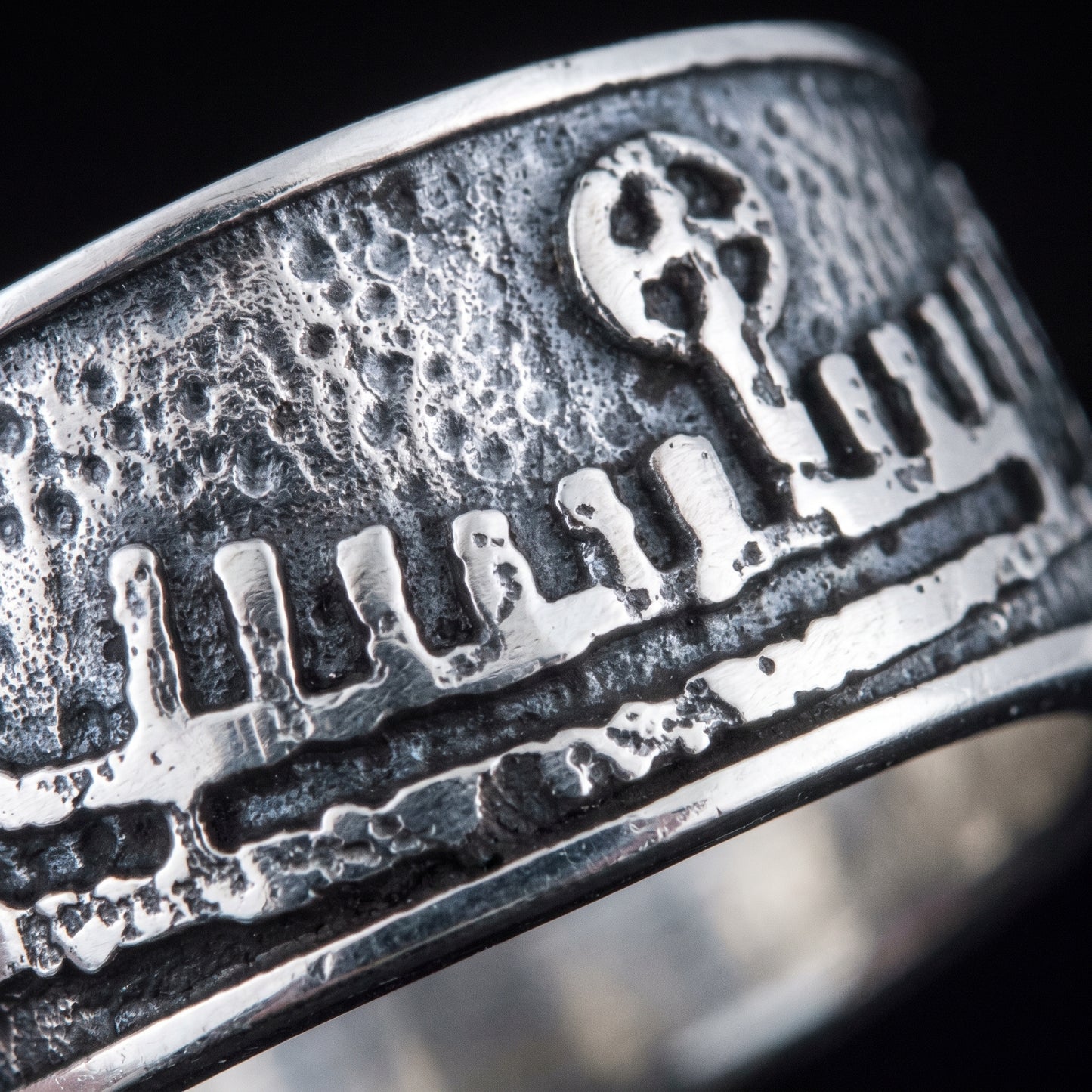 Macro of the cast Norse longship relief, hull, shields and mast on the silver band