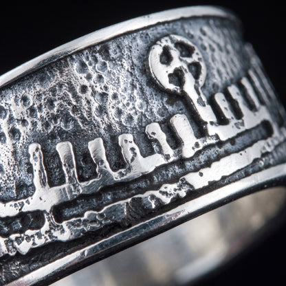 Macro of the cast Norse longship relief, hull, shields and mast on the silver band