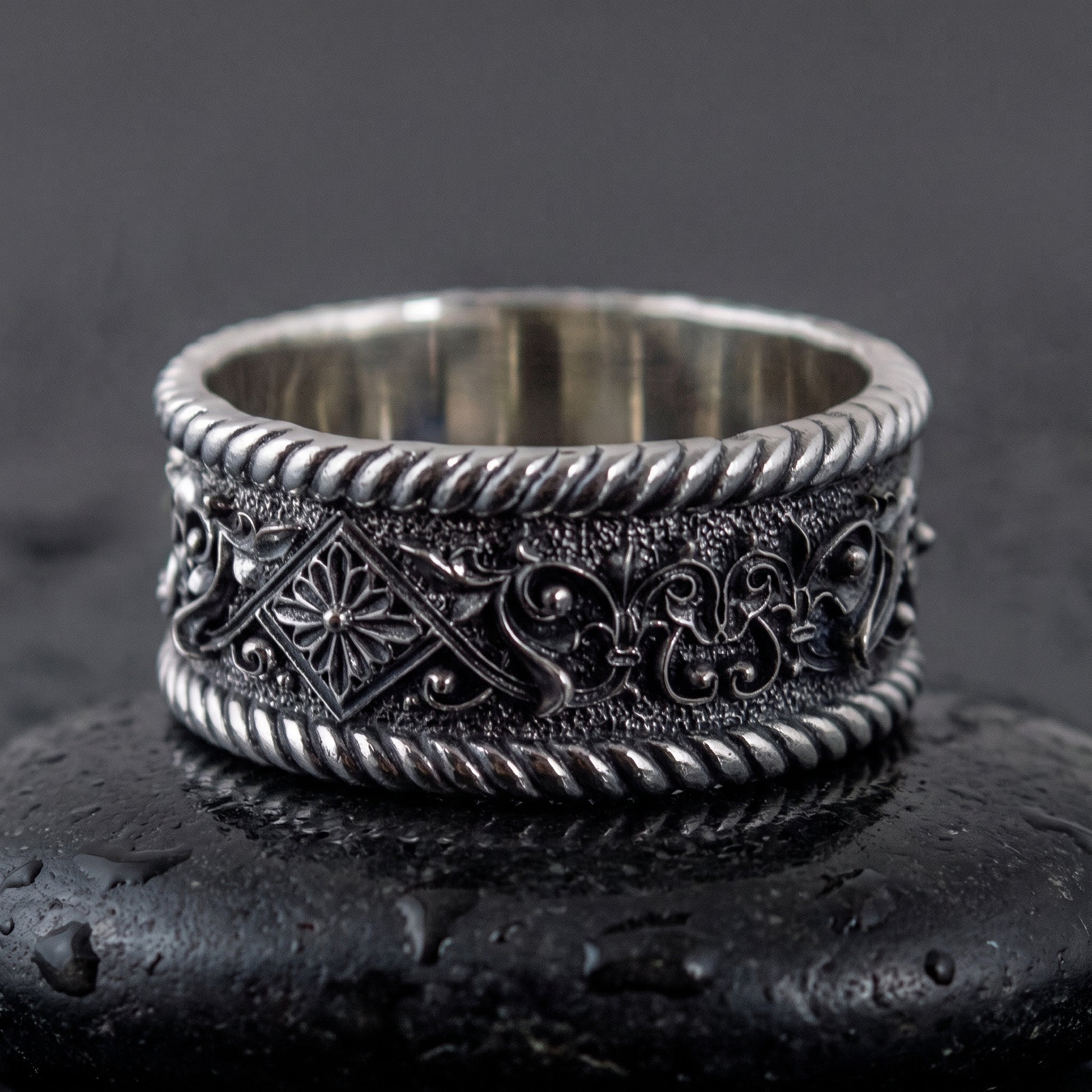 Sterling silver Viking ring facing forward, rosette panel and foliate scrollwork on the band