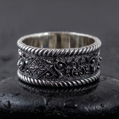 Sterling silver Viking ring facing forward, rosette panel and foliate scrollwork on the band