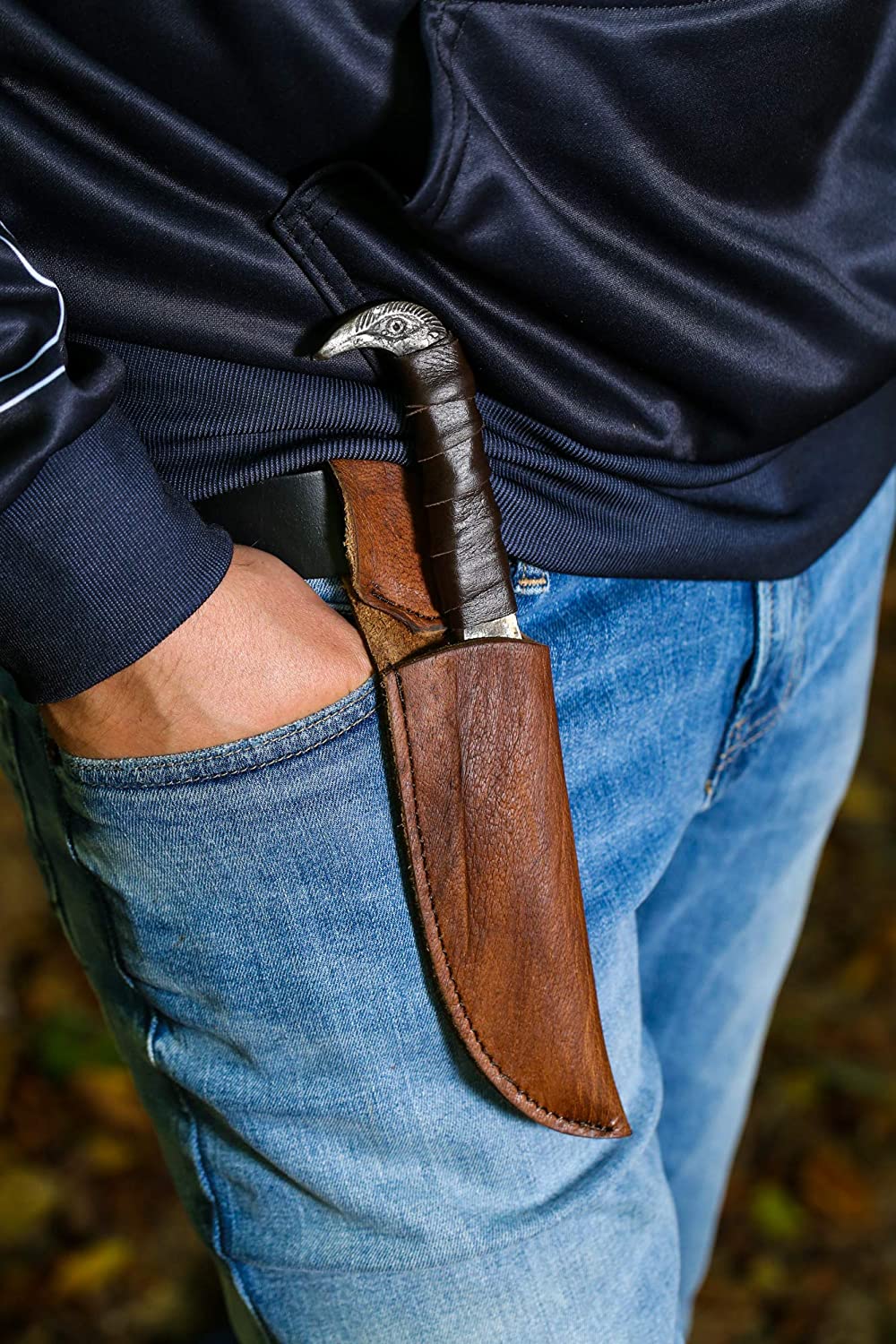 Odin's Raven Viking seax knife sheathed on a leather belt, raven's head pommel visible at the hip