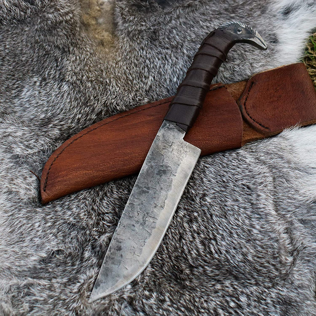 Odin's Raven Viking seax knife and its handmade cowhide leather sheath laid on grey fur
