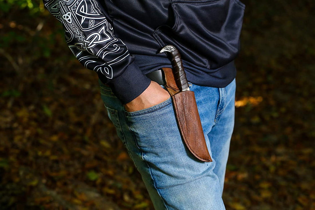 Odin's Raven seax knife carried in its leather belt sheath on a person's hip outdoors