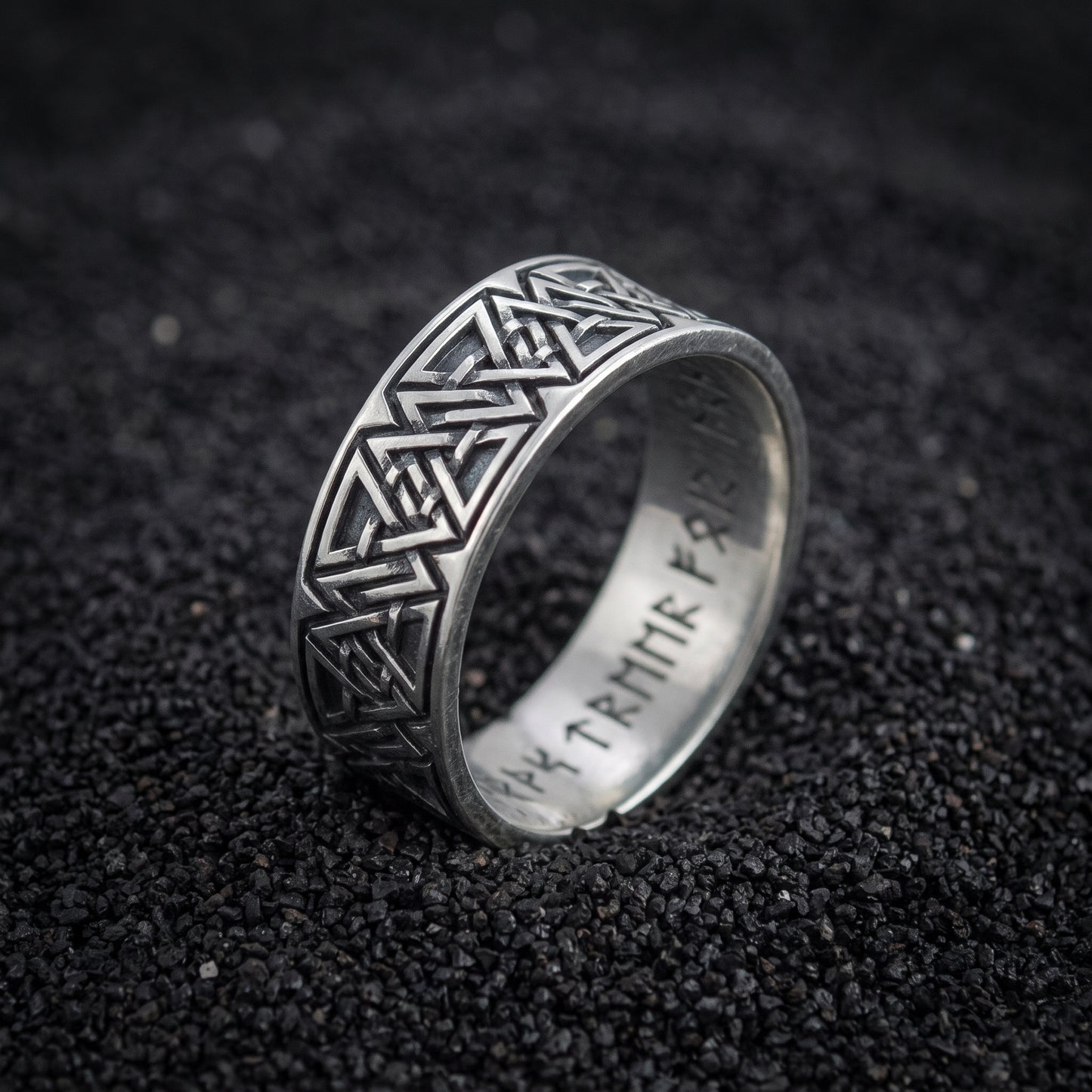 Valknut and rune band ring in 925 sterling silver on black volcanic sand